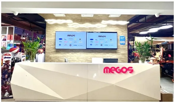 MEGOSのロゴが入った受付カウンターの画像です。