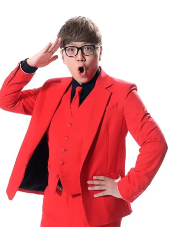 赤いスーツを着た男性が敬礼のポーズをしている様子