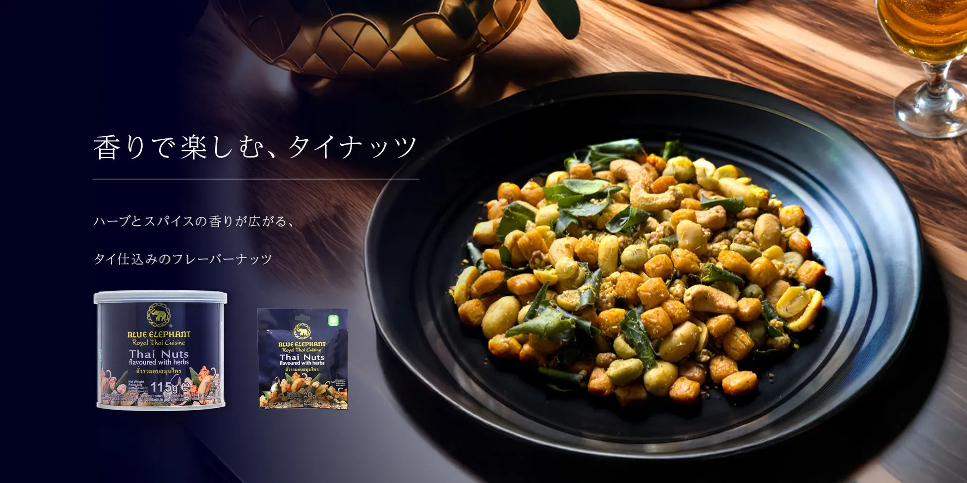 タイ料理のフレーバーナッツの広告。黒い皿に盛り付けられたナッツと、ナッツの缶と袋が写っています。ナッツはハーブとスパイスで味付けされ、香りが特徴です。