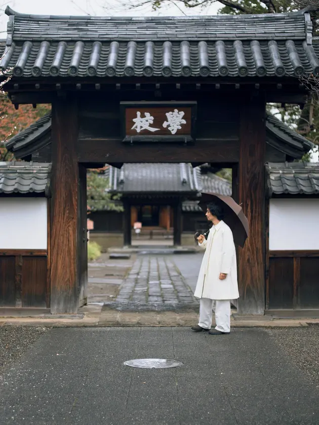 足利学校のような歴史的建造物の前に立つ斎藤工さん