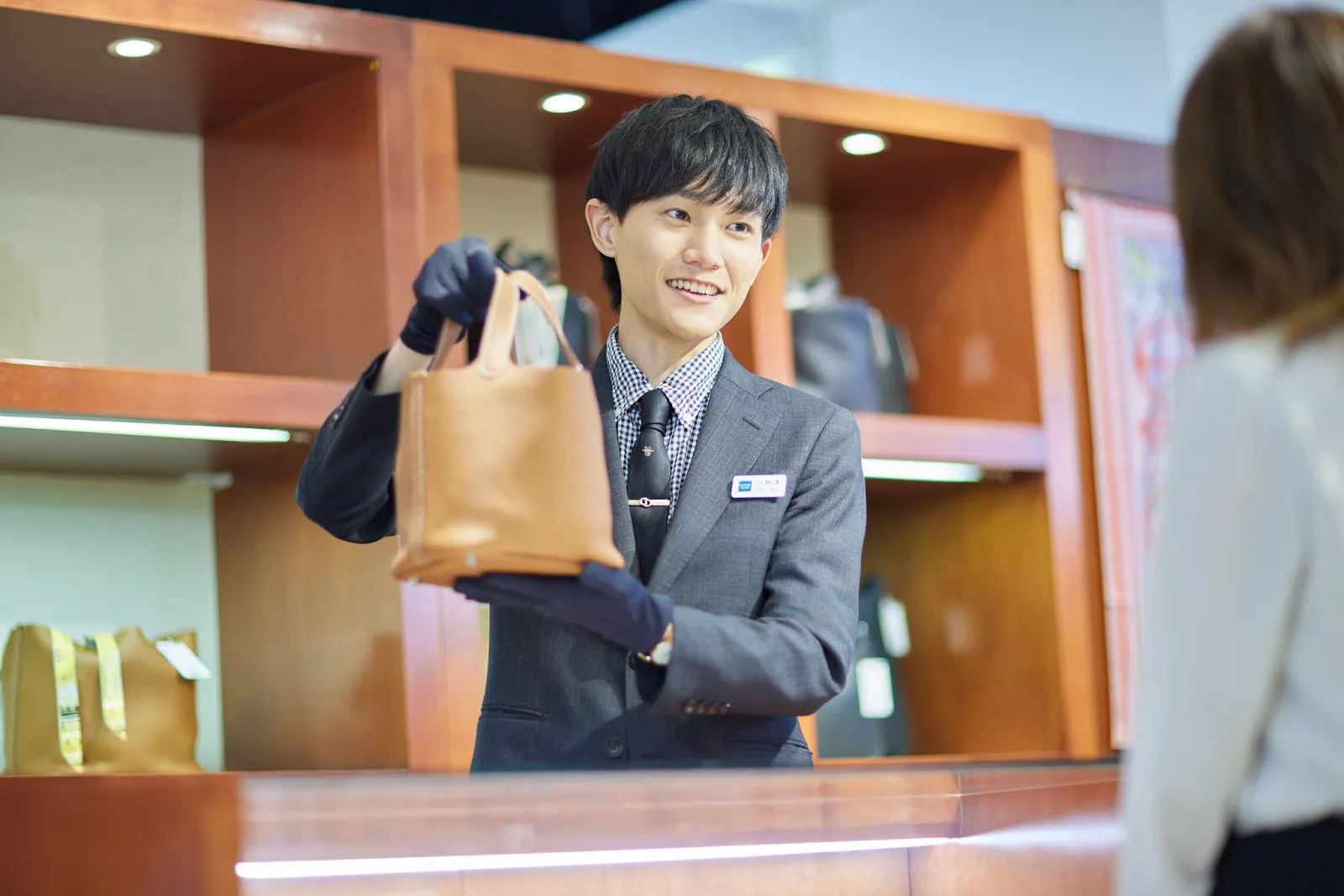 店員がバッグを客に見せている様子。
