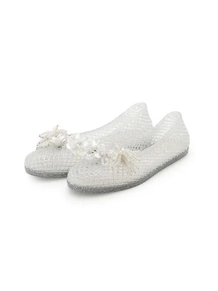 白い装飾が施された透明なフラットシューズのクローズアップ写真