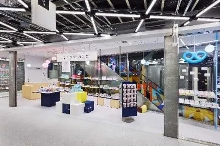 店内。お菓子や雑貨が並べられており、奥には階段と遊具が見える。