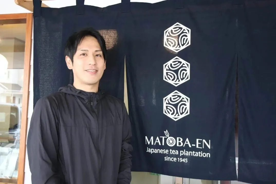 男性がMATOBA-ENの看板の前で立っている写真。