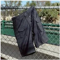 フェンスに掛けられた濃い色のカーゴショーツ