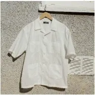 白い半袖シャツが壁に掛けられている様子。