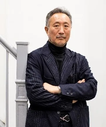 階段の手すりに寄りかかって腕を組んでいる男性のポートレート