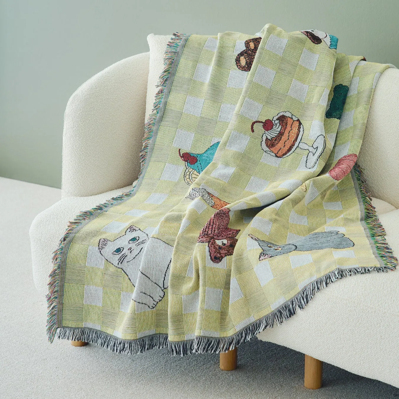 チェック柄と動物やデザートのイラストが描かれたブランケット