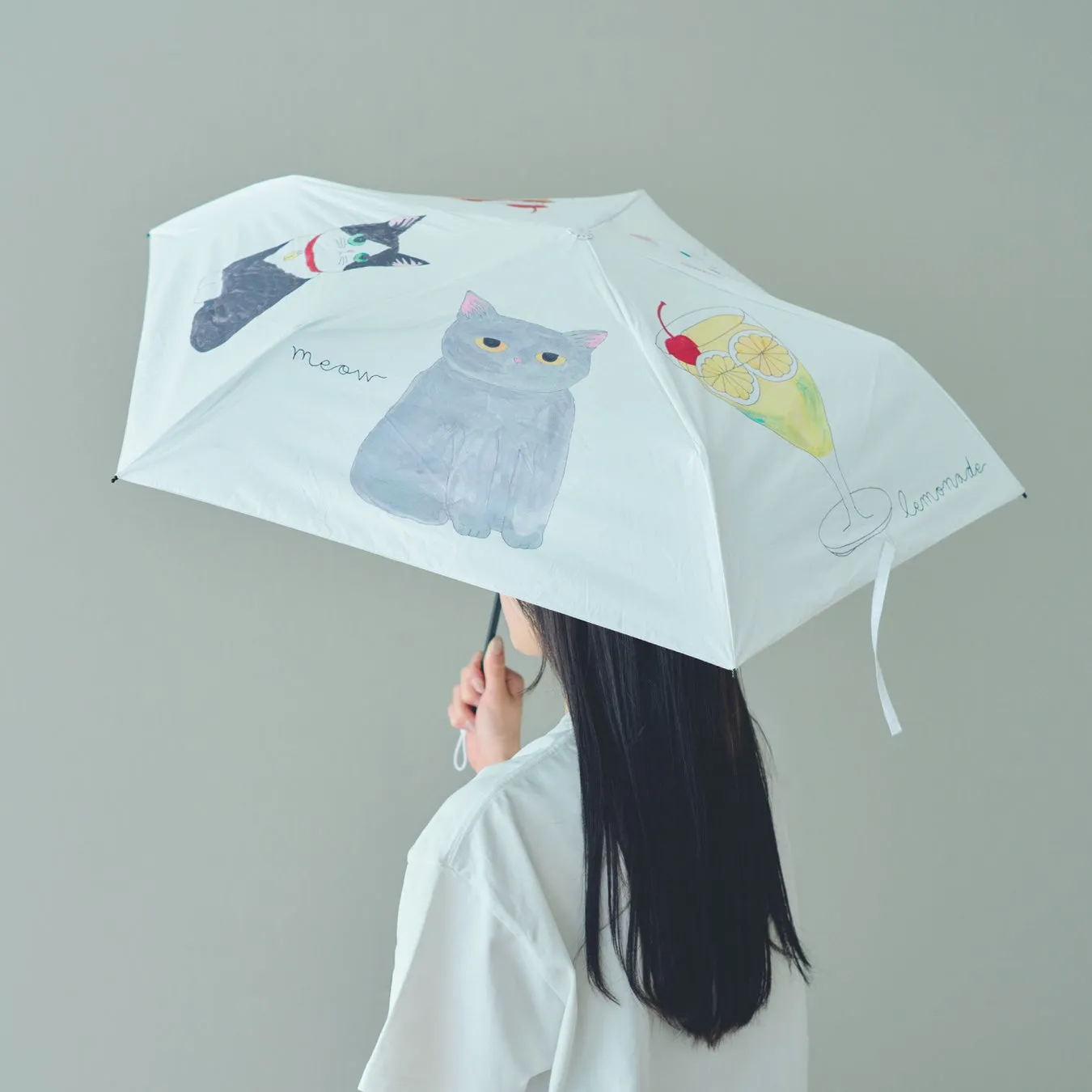 白い傘をさしている女性の後ろ姿