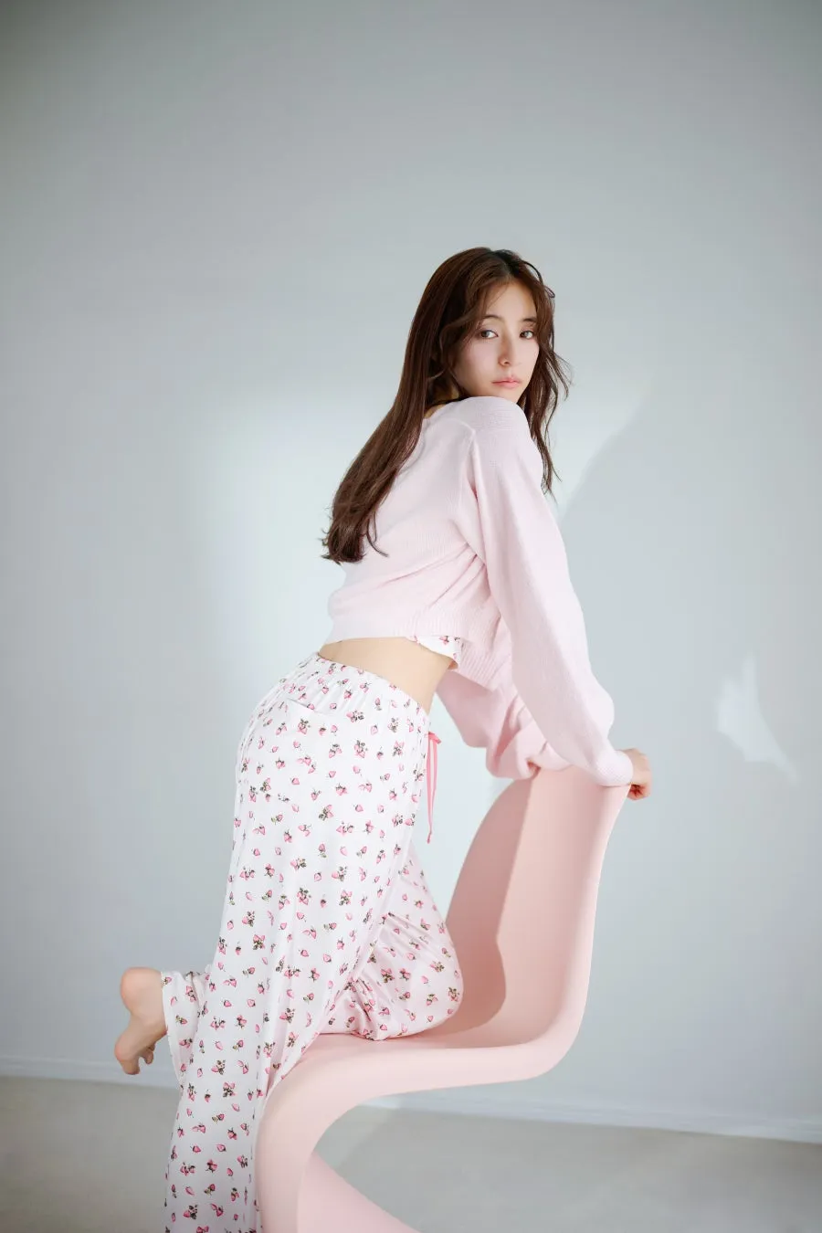 ピンクのセーターとイチゴ柄パジャマの女性