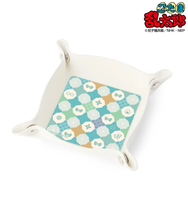 白いトレイの上に、幾何学模様のイラストが描かれたトレイが置かれています。トレイの角には留め具が付いています。