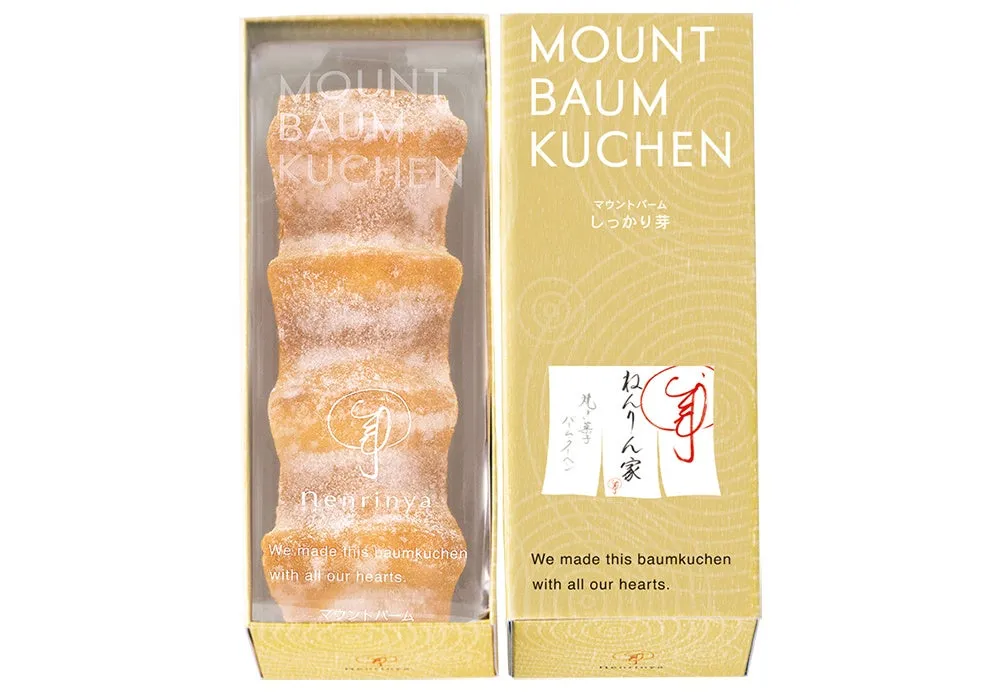 バウムクーヘンが箱に入った写真。箱には「MOUNT BAUM KUCHEN」の文字と、日本語で「マウントバーム しっかり芽」と書かれています。また、バウムクーヘンが「ねんりん家」のものであることも記載されています。