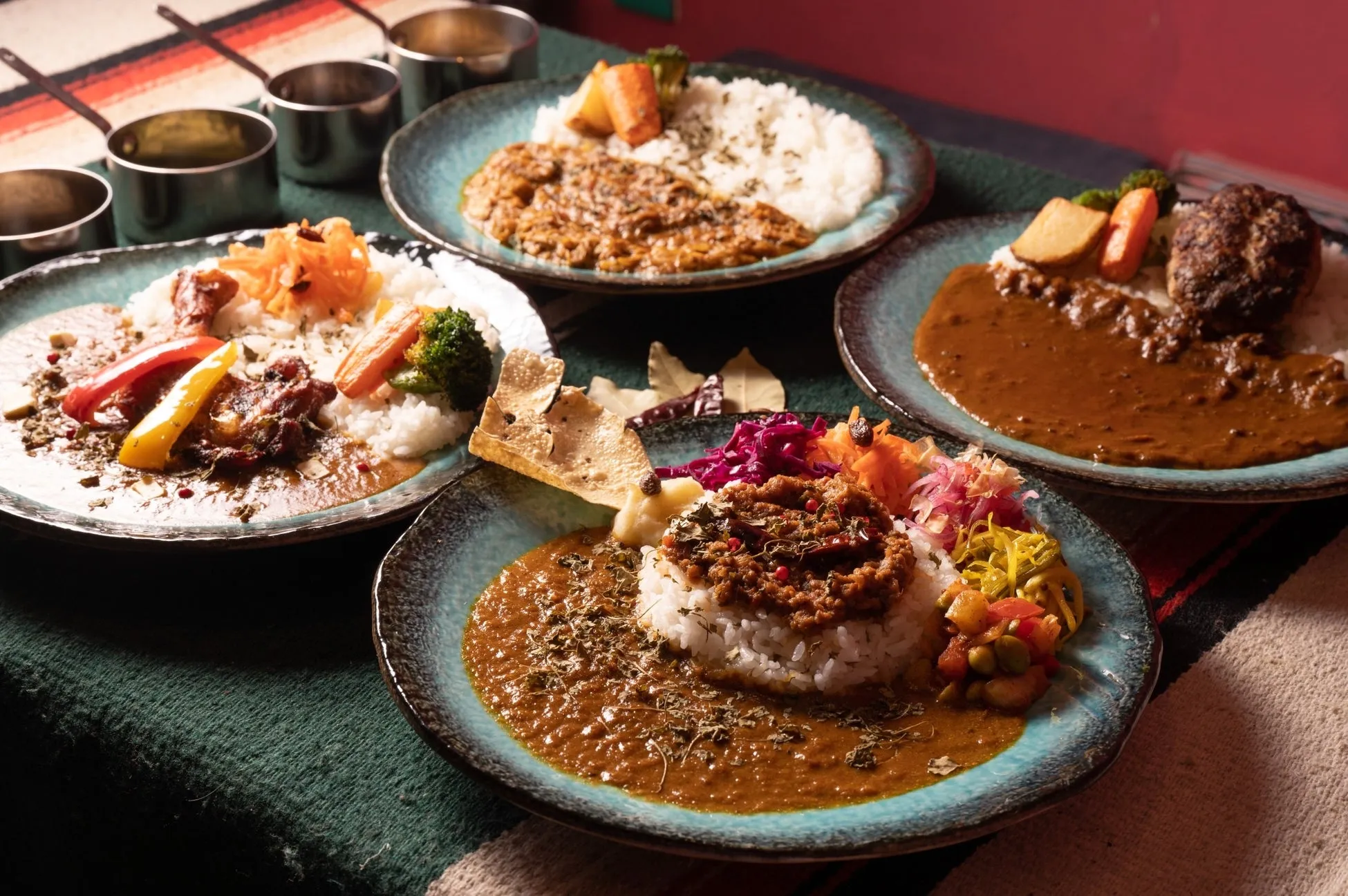 カレーライスの盛り合わせの画像。様々なトッピングとカレーソースが添えられており、彩り豊か。