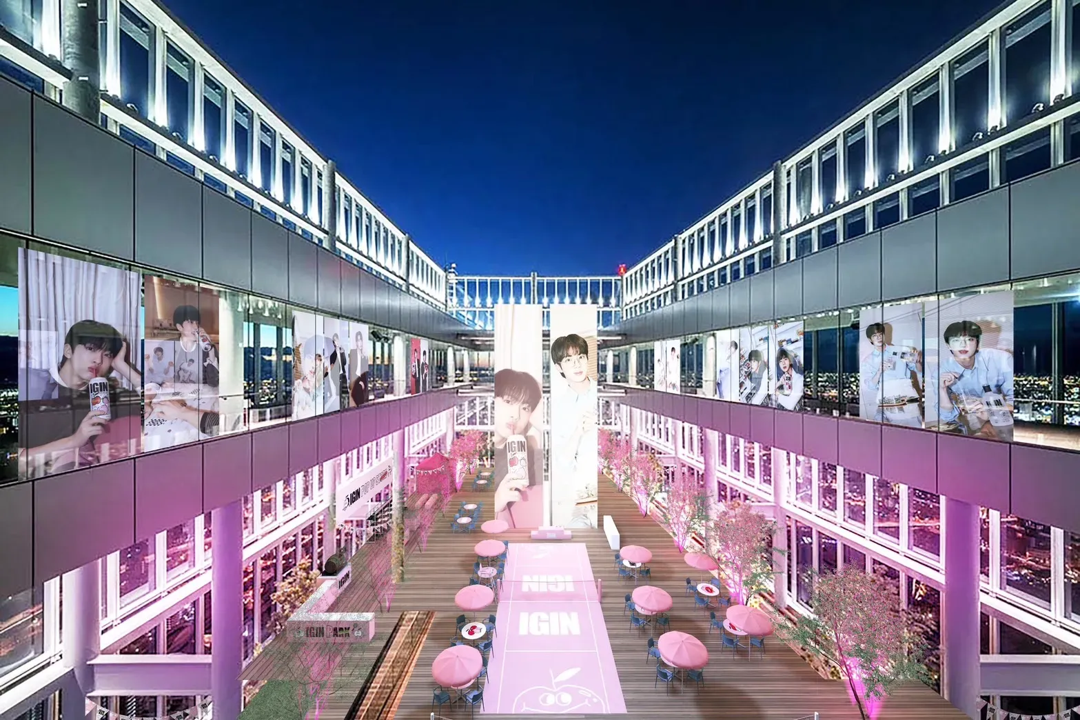 夜景を背景に、アイドルと思われる人物の写真が飾られたイベント会場の様子。ピンクを基調とした装飾が施され、カフェスペースも設けられている。