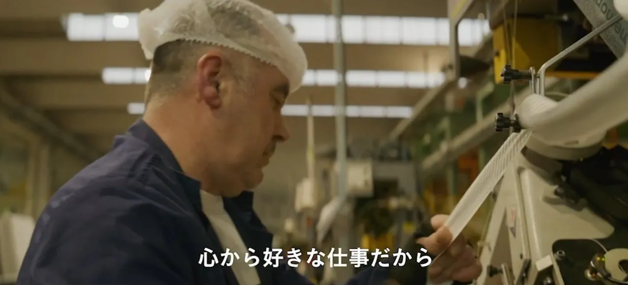 工場で働く男性が、機械を操作している様子。