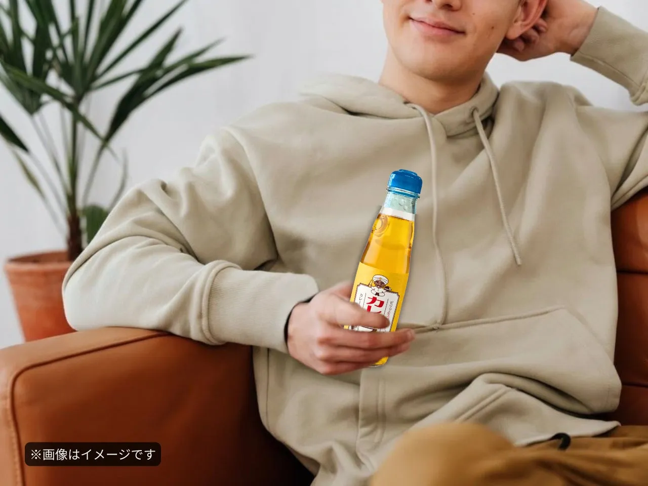 男性がカレー味のラムネ瓶を持っています
