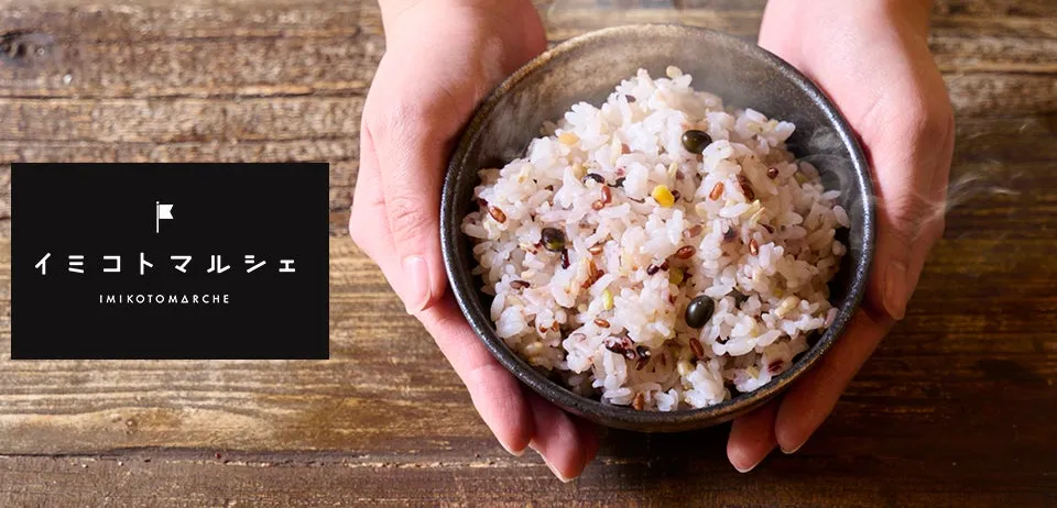 手で持たれた器に入った五穀米の写真。湯気が立っている。