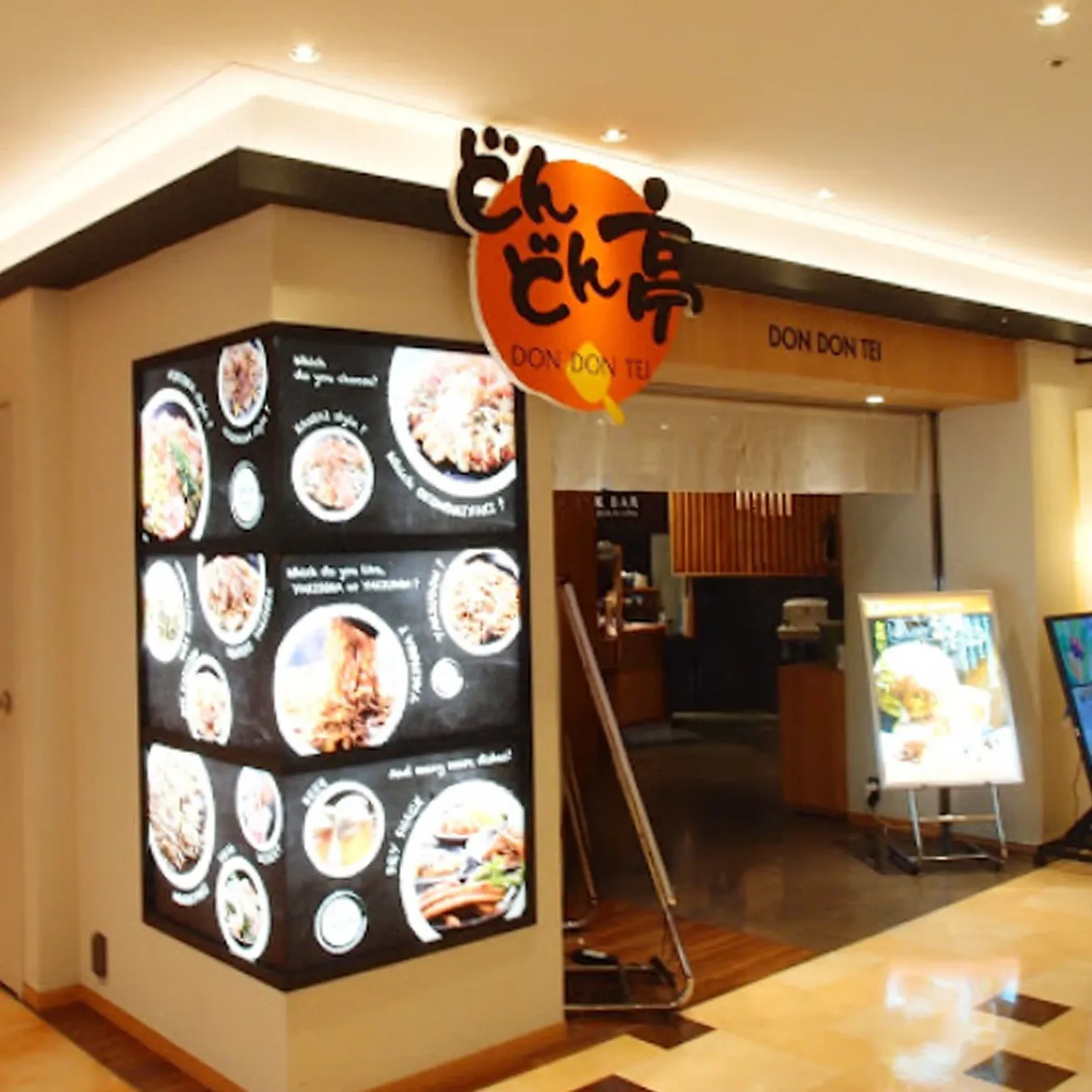レストランの入り口の写真です。「DON DON TEI」という看板があり、メニューのディスプレイがあります。