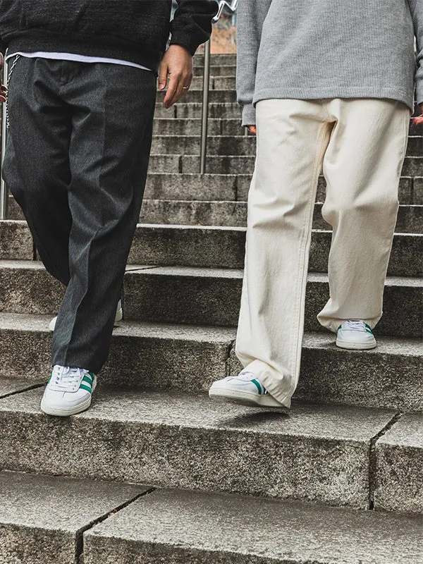 階段を降りる2人の男性。一人はグレーのズボンと白いスニーカー、もう一人は白いズボンと白いスニーカーを履いている。