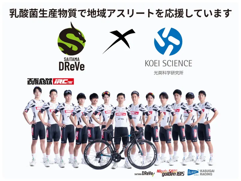 サイクリングチームの写真。チームのメンバーが白い服を着ており、自転車の前に立っている。ロゴやスポンサーのロゴも見える。