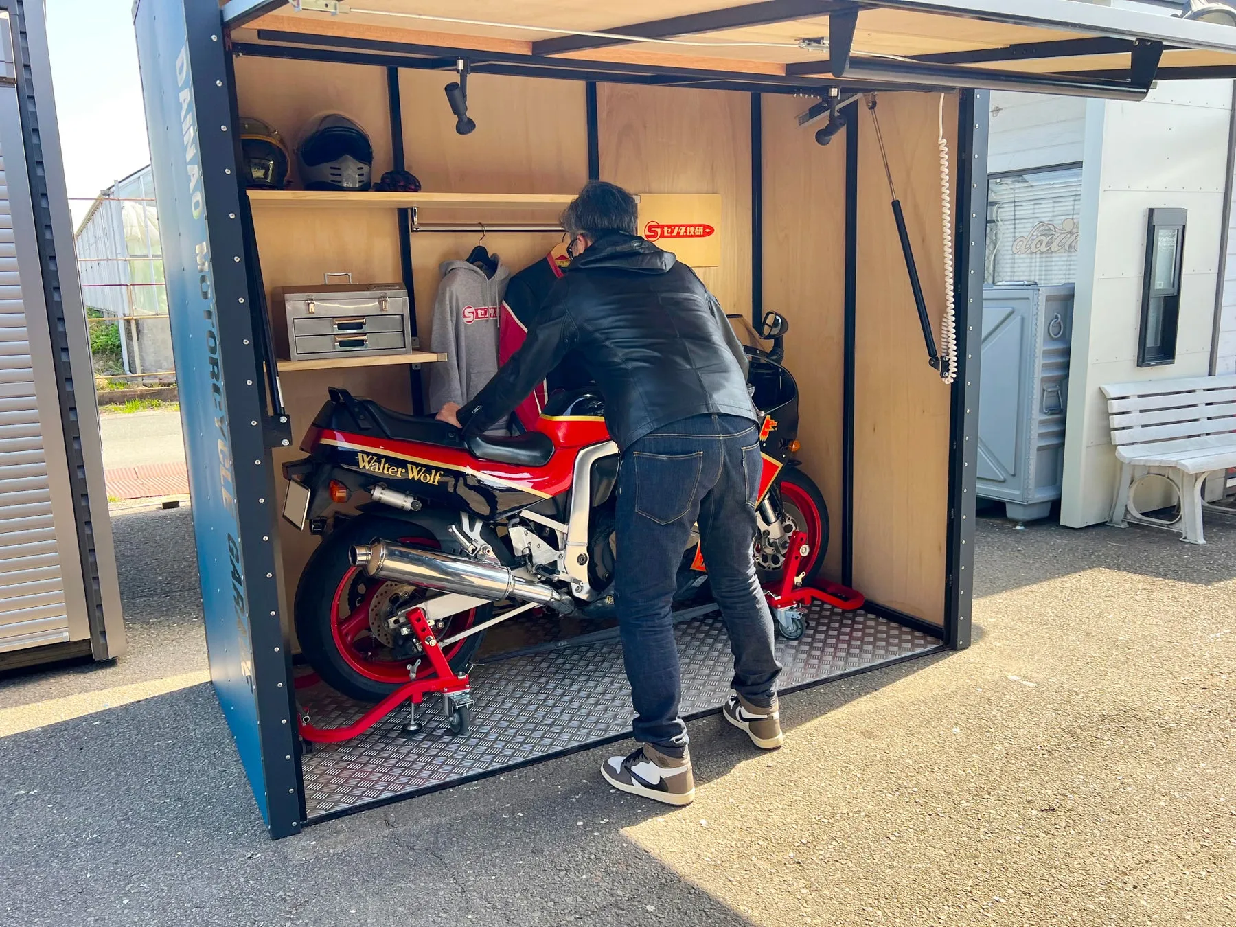 バイクが格納された小屋にいる男性