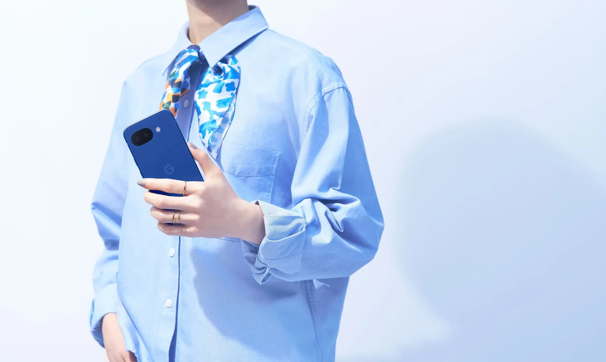 青いスマートフォンを持つ女性の画像です。