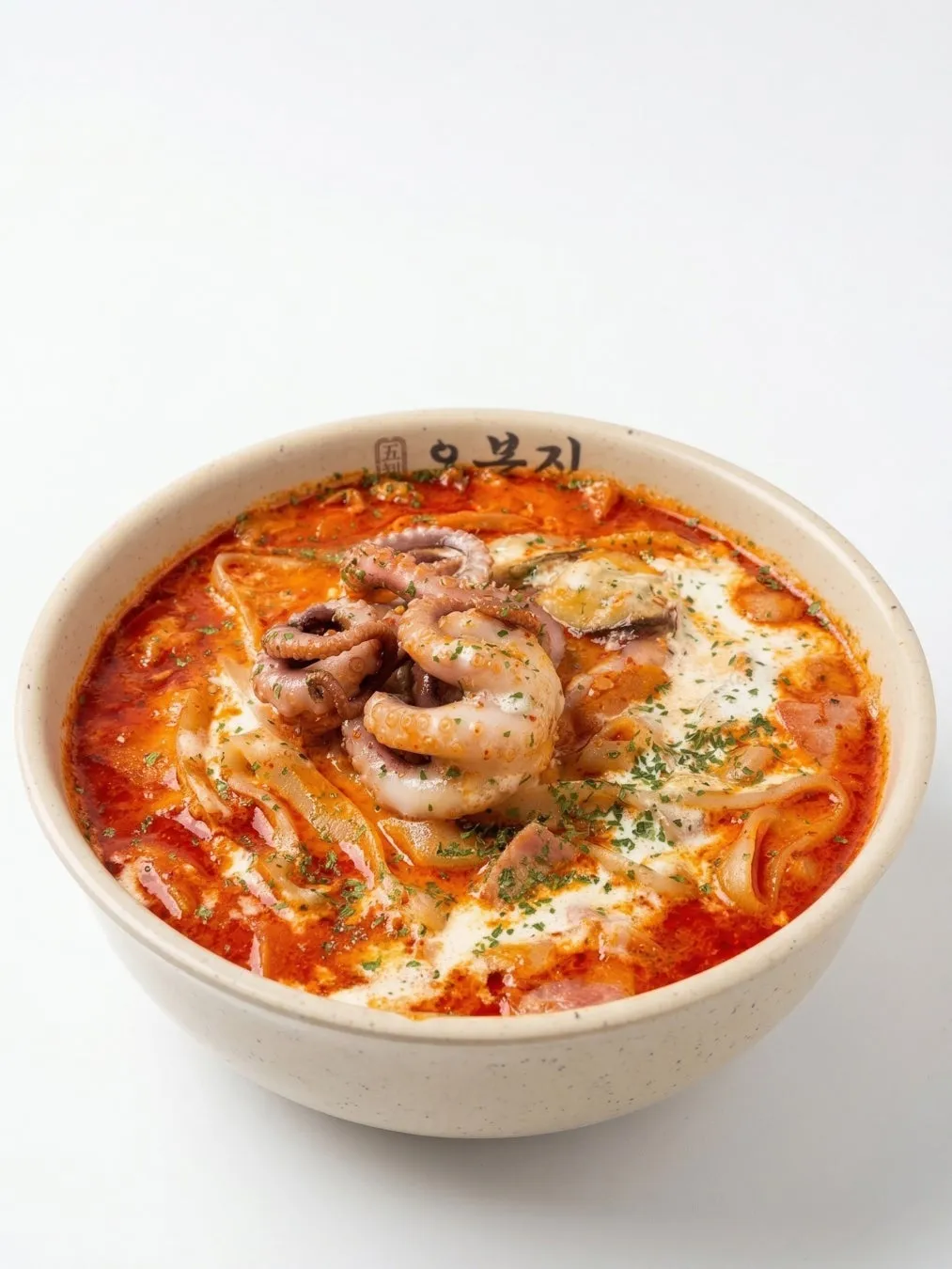 赤いスープにタコ、エビ、ベーコン、クリームがトッピングされた料理の写真です。