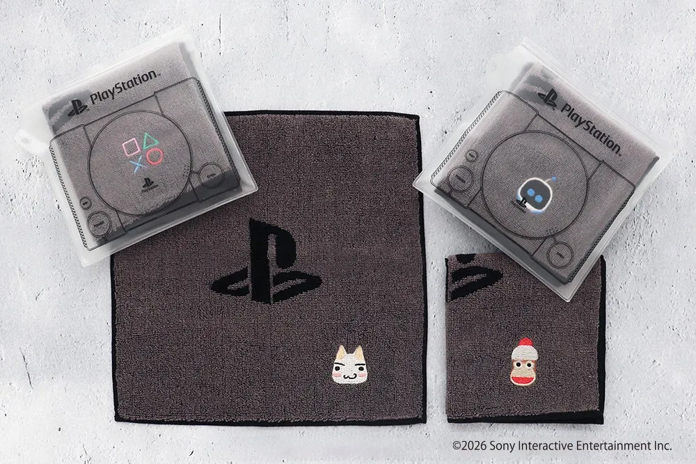 PlayStationのロゴやキャラクターがデザインされたタオルセットの写真です。タオルはグレーで、PlayStationのコントローラーやロゴが刺繍されています。また、猫や靴下のキャラクターの刺繍も施されています。