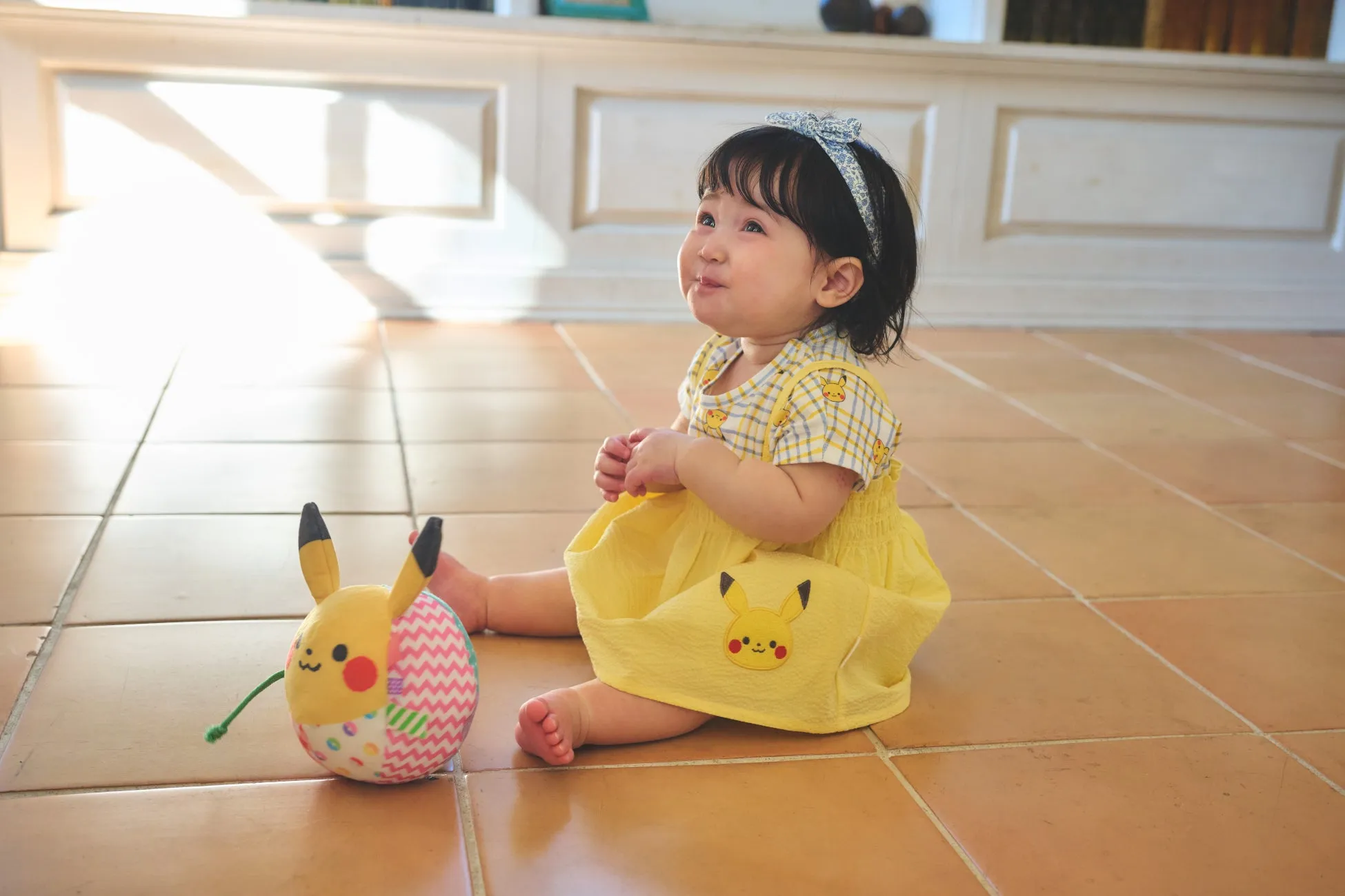 ピカチュウのぬいぐるみを抱く赤ちゃん