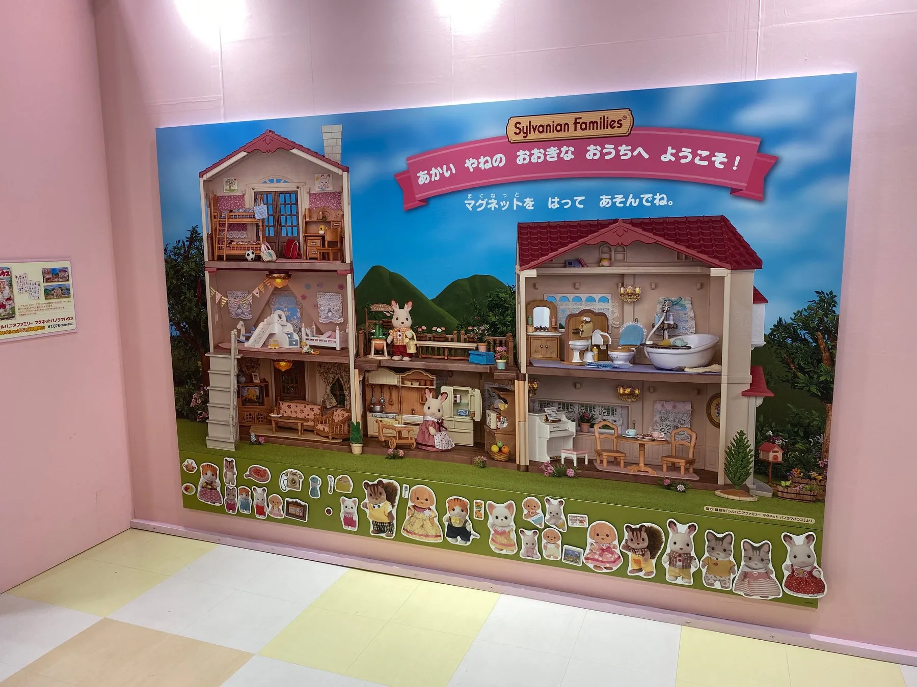 シルバニアファミリーのマグネットパノラマハウスの展示。赤い屋根の大きな家で遊ぶ様子が描かれており、マグネットを使って遊ぶことができる。