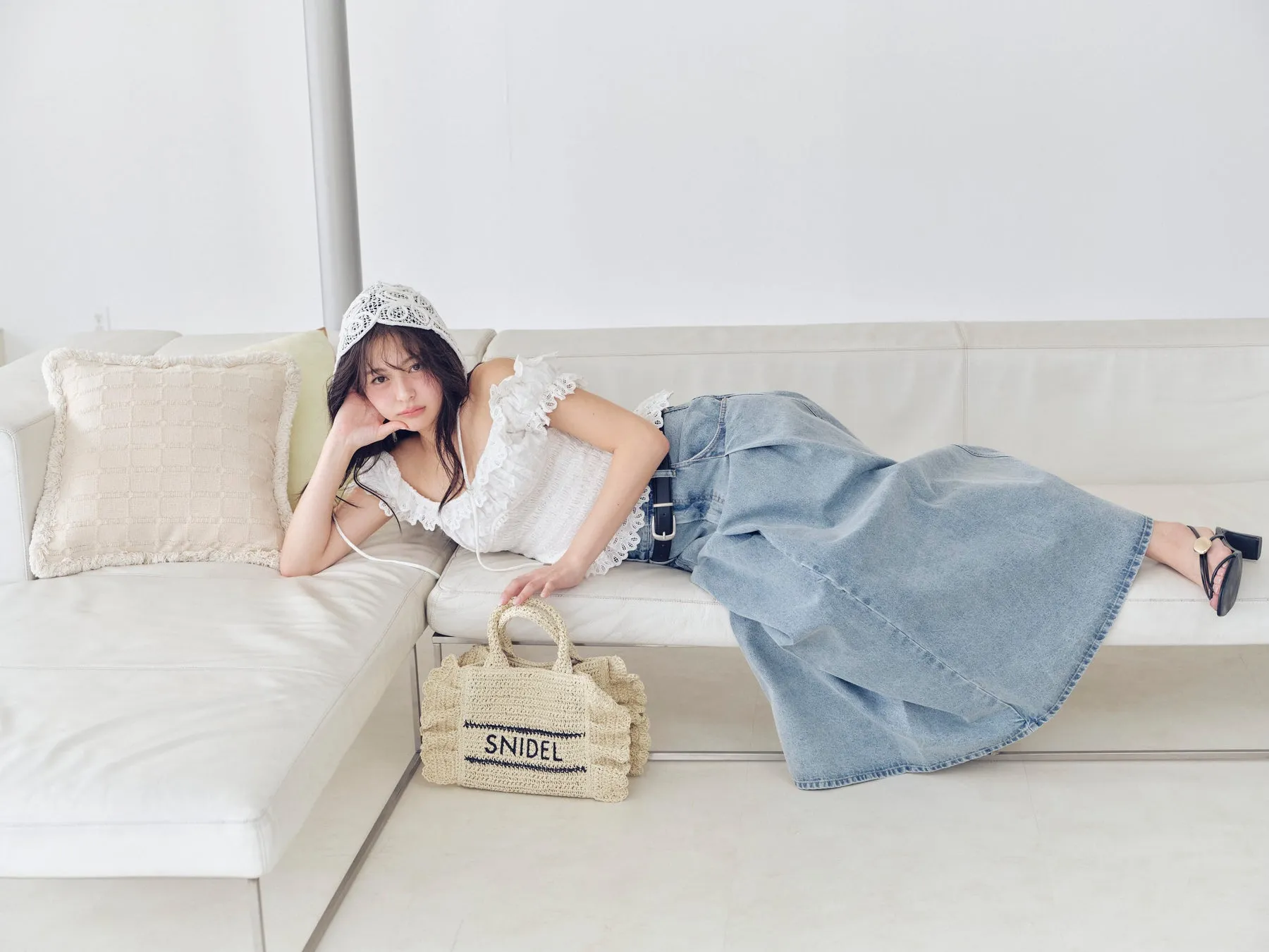 白レースの帽子とデニムスカートの女性（ソファ）
