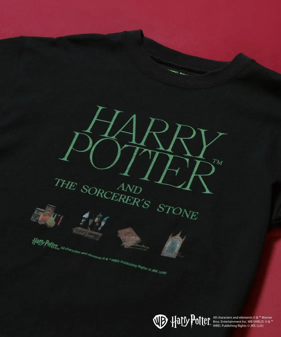 ハリーポッターのTシャツ。前面には、緑色の文字で「HARRY POTTER AND THE SORCERER'S STONE」と書かれています。Tシャツの裾には、ハリーポッターのロゴと、著作権情報が記載されています。