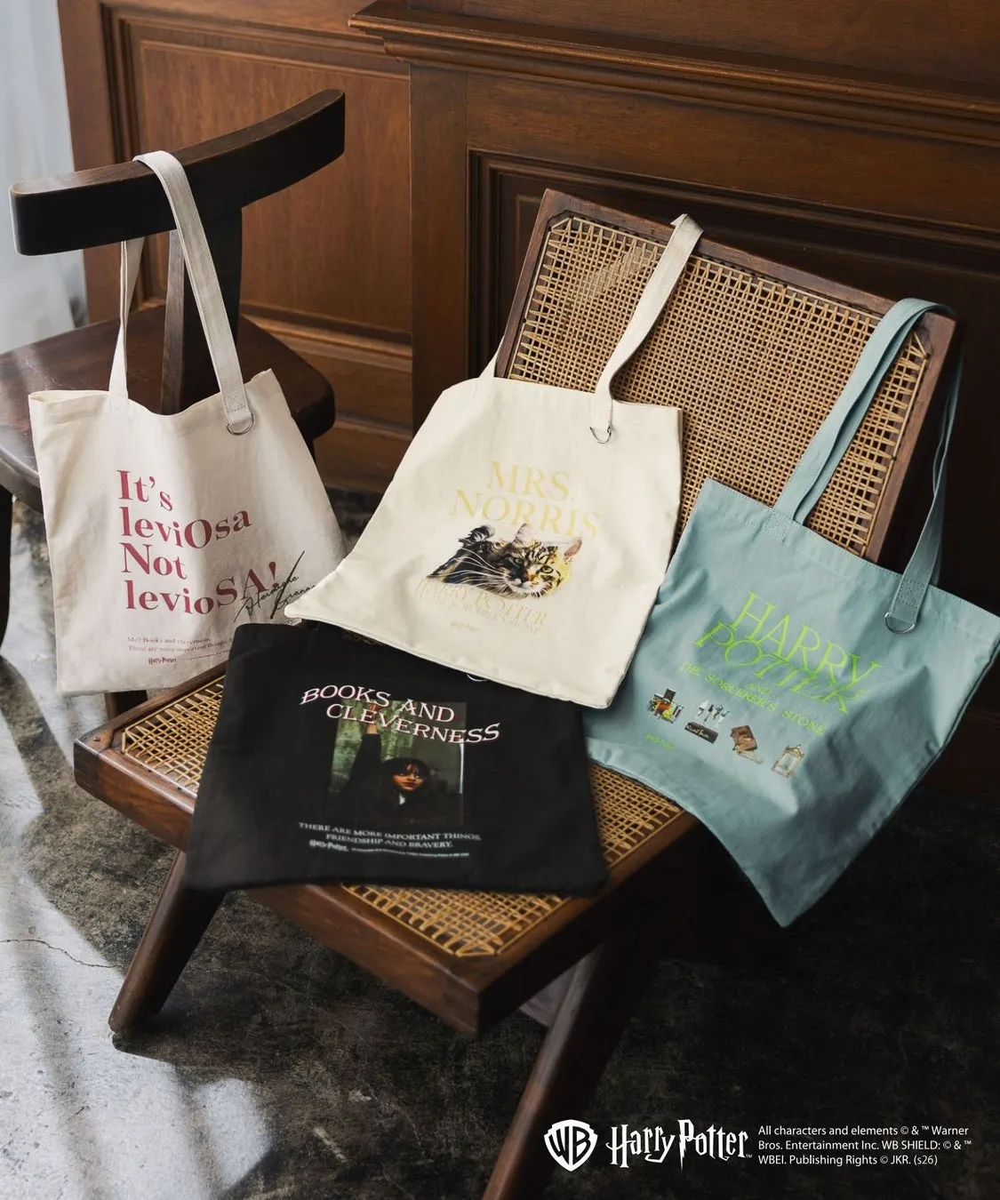 ハリーポッターのトートバッグが椅子にいくつか置かれている様子を描いた写真。各バッグには、映画や本のテーマに関連するテキストや画像が描かれています。