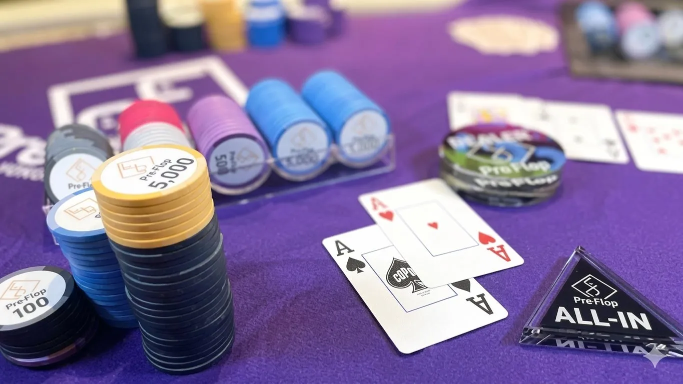 ポーカーテーブルのクローズアップ写真。ポーカーチップ、カード、ALL-INサインが写っています。