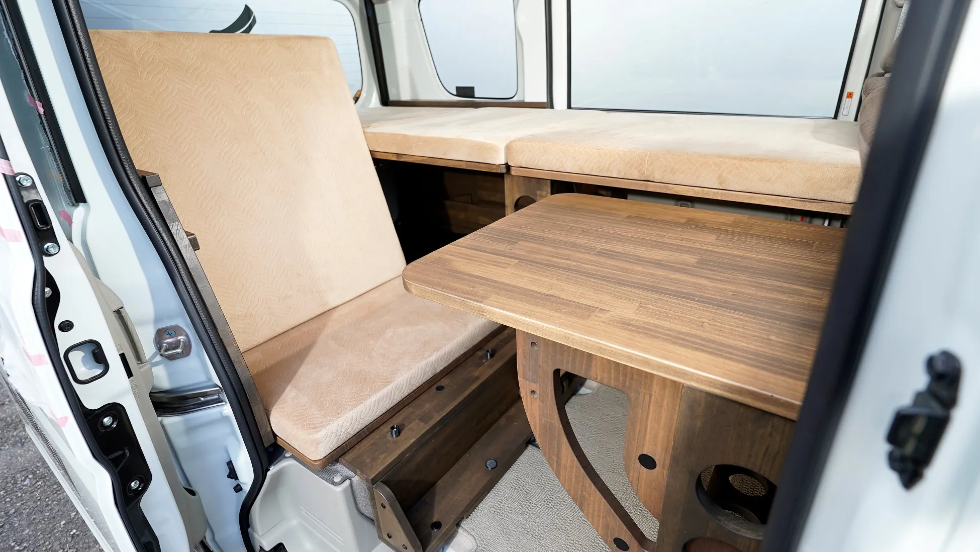 木製テーブルとベンチシートの車内インテリア