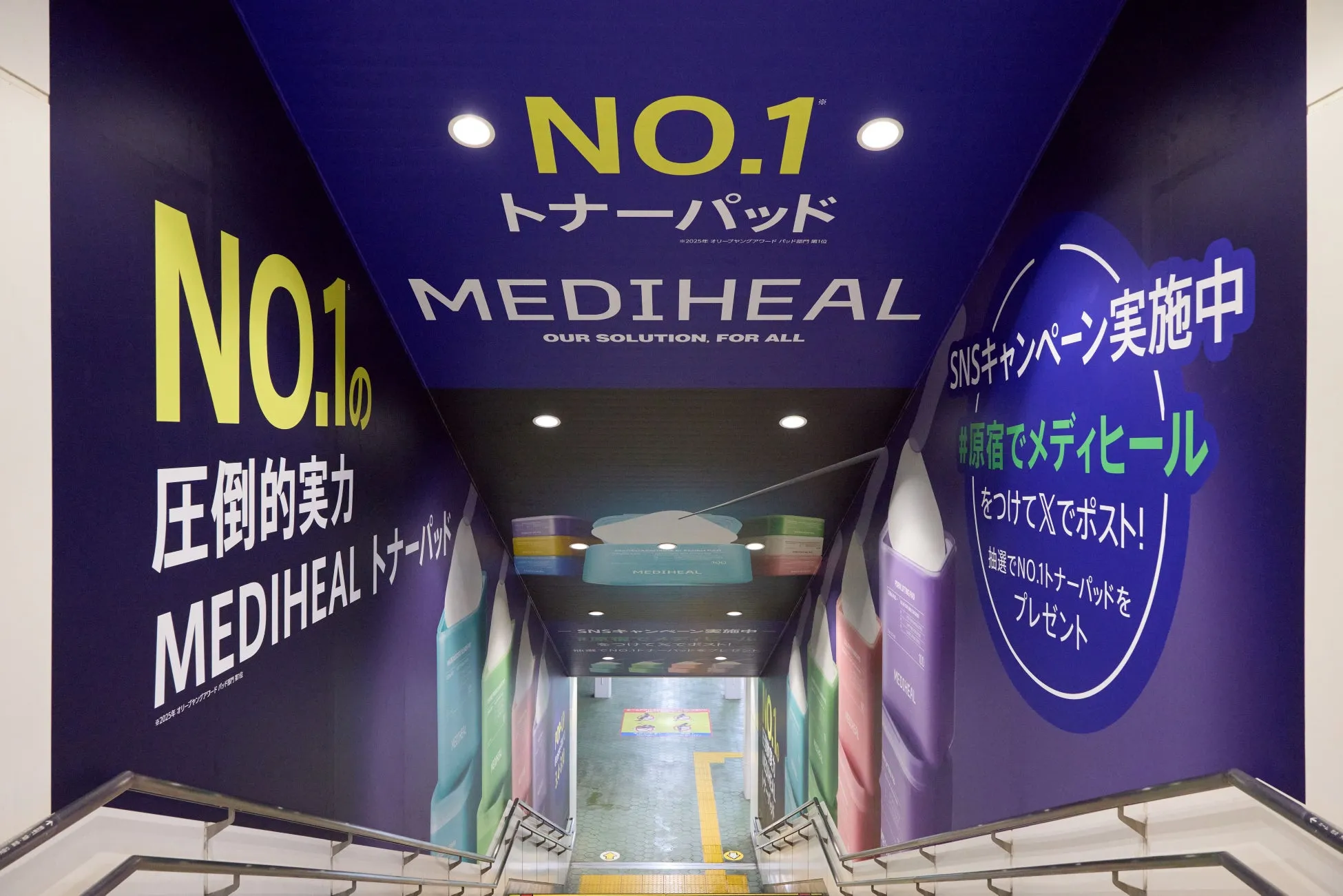 階段の壁面に貼られたMEDIHEALの広告。NO.1トナーパッドのキャンペーンが実施されている。