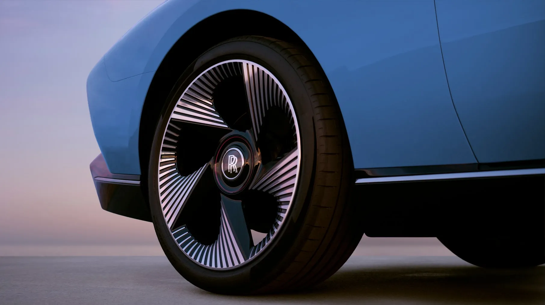 青色の車体のロールスロイスのホイールのクローズアップです。ホイールには、ロールスロイスのロゴが中央に配置されています。