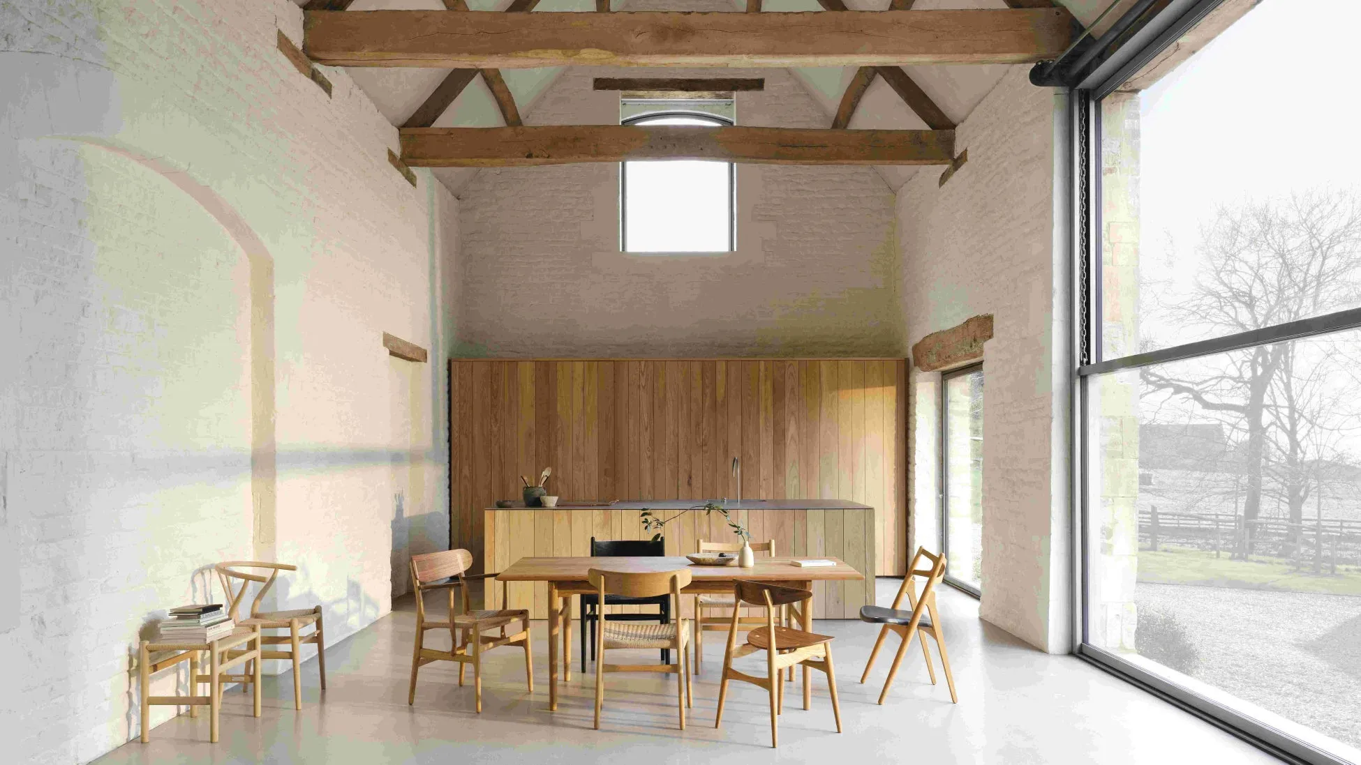 木製の梁と白いレンガの壁が特徴的な、洗練されたダイニングルーム。