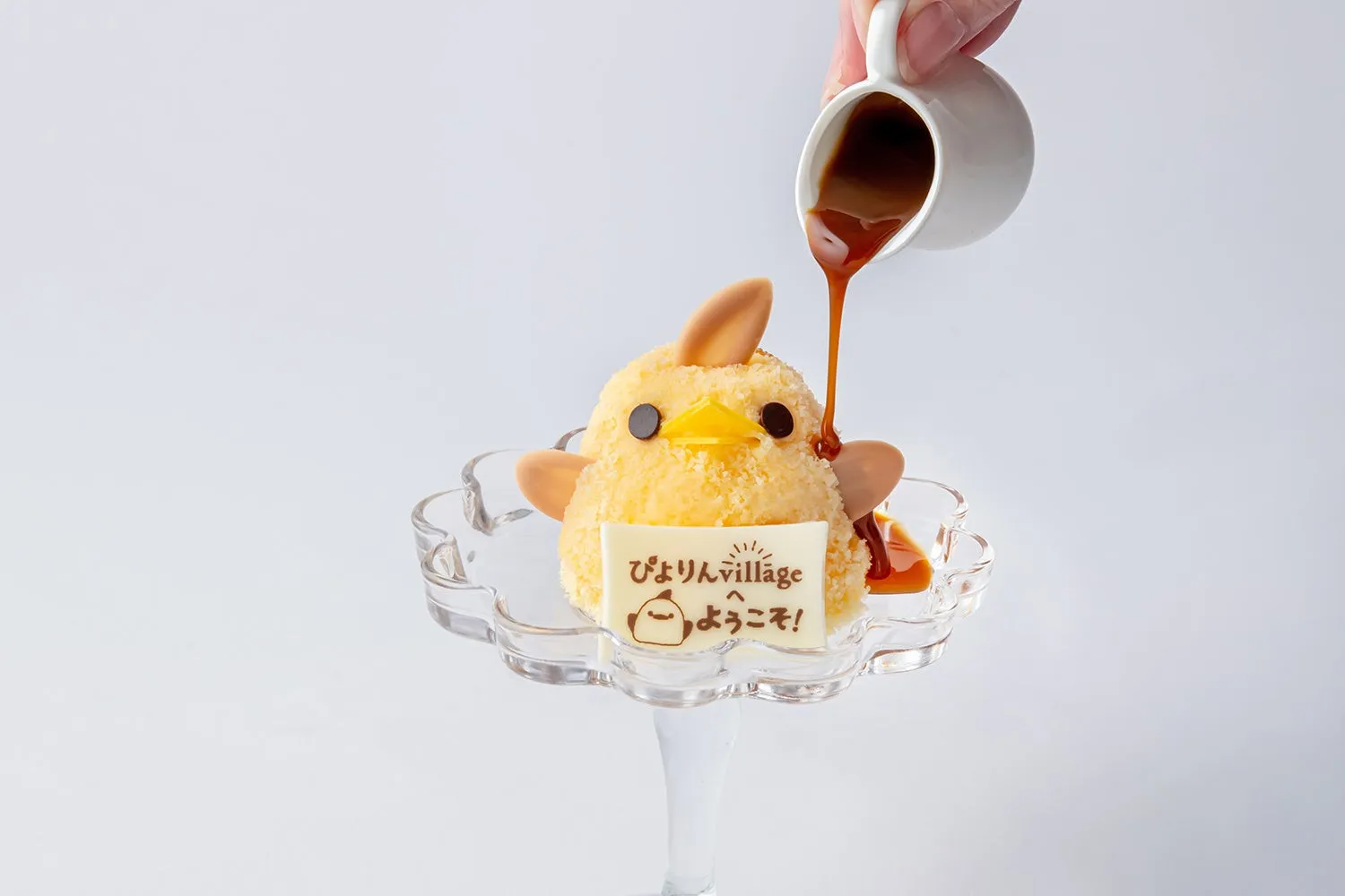 ひよこの形をしたデザートにソースをかけている様子