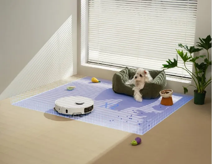 犬とロボット掃除機が写った画像。犬はベッドに座っており、掃除機は床を掃除している。