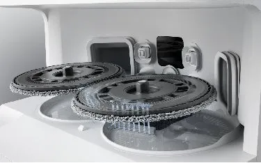 洗濯機の内部構造のクローズアップ写真。二つの回転する円盤状の部品があり、水が流れ落ちる様子が描写されています。