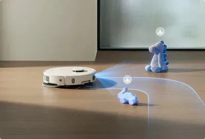 ロボット掃除機が、床にあるおもちゃを避けながら掃除をしている様子。