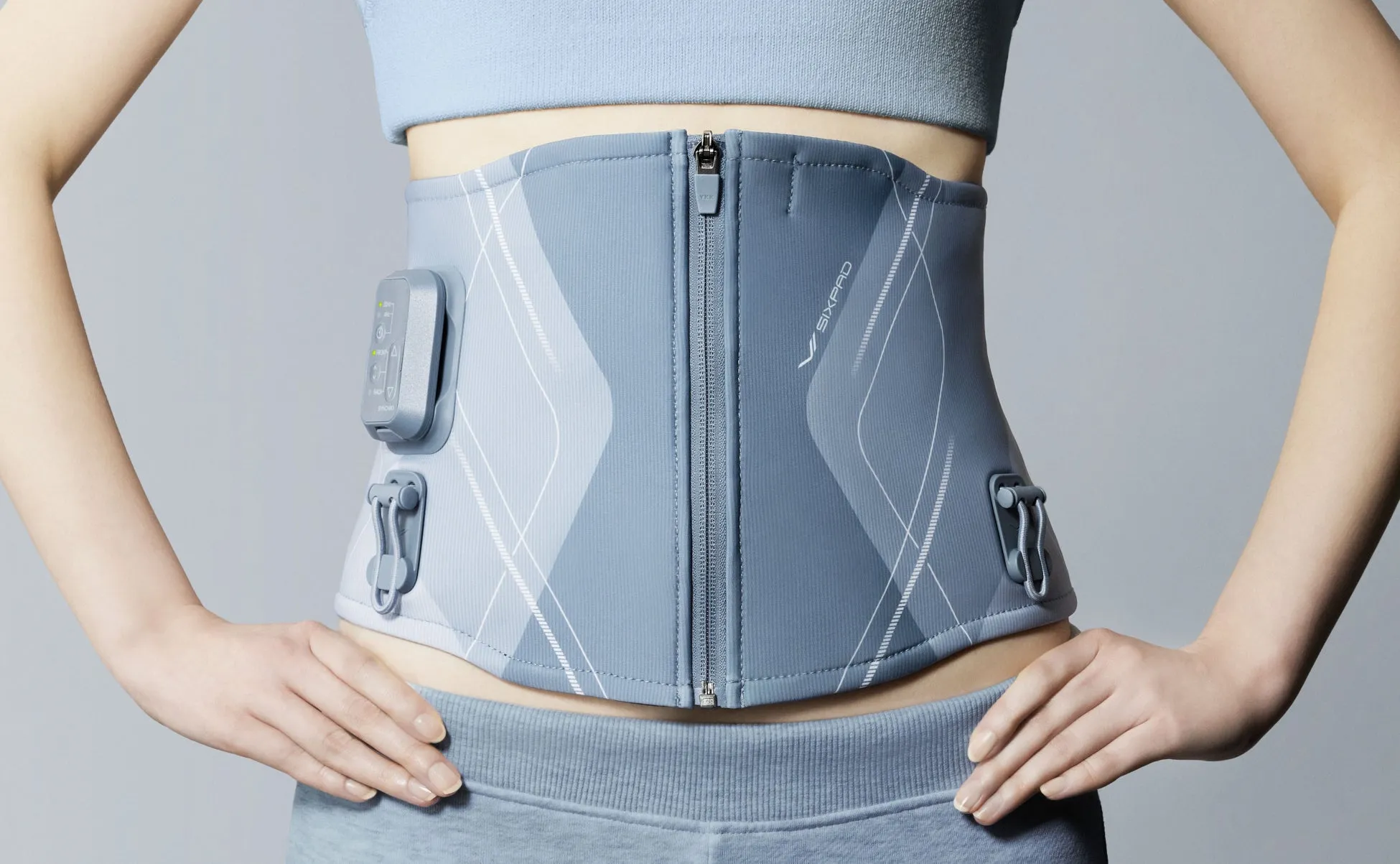 女性が腹部にEMSベルトを装着している様子