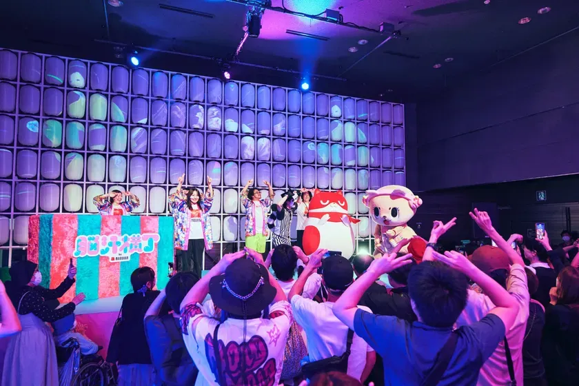 ステージ上でパフォーマンスをするアーティストと、観客の様子