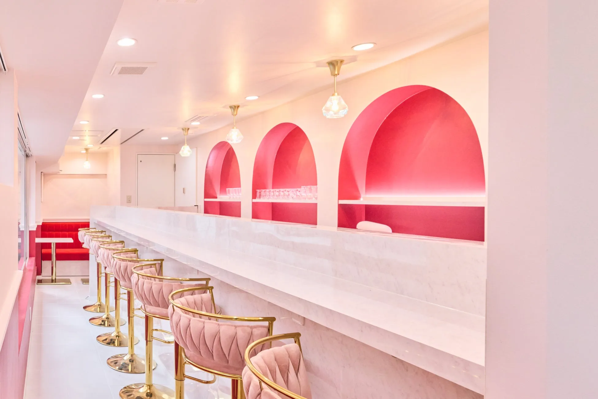 ピンクを基調とした内装のバーカウンター。アーチ型の装飾や、ベルベットの椅子が特徴的。