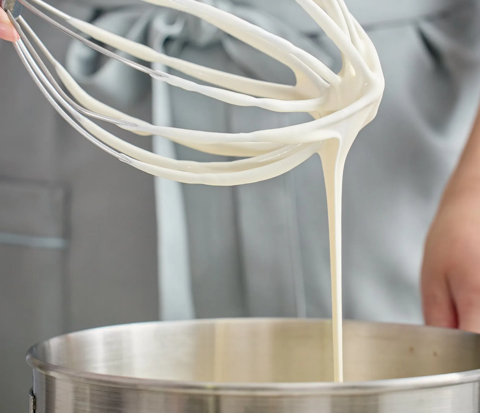 泡立て器から落ちるクリームのクローズアップ