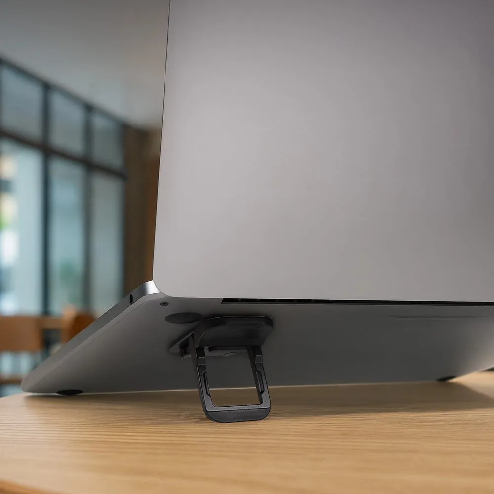 ノートパソコンの下に設置されたスタンドのクローズアップ写真。スタンドはノートパソコンを持ち上げ、画面の角度を調整するために使用されます。