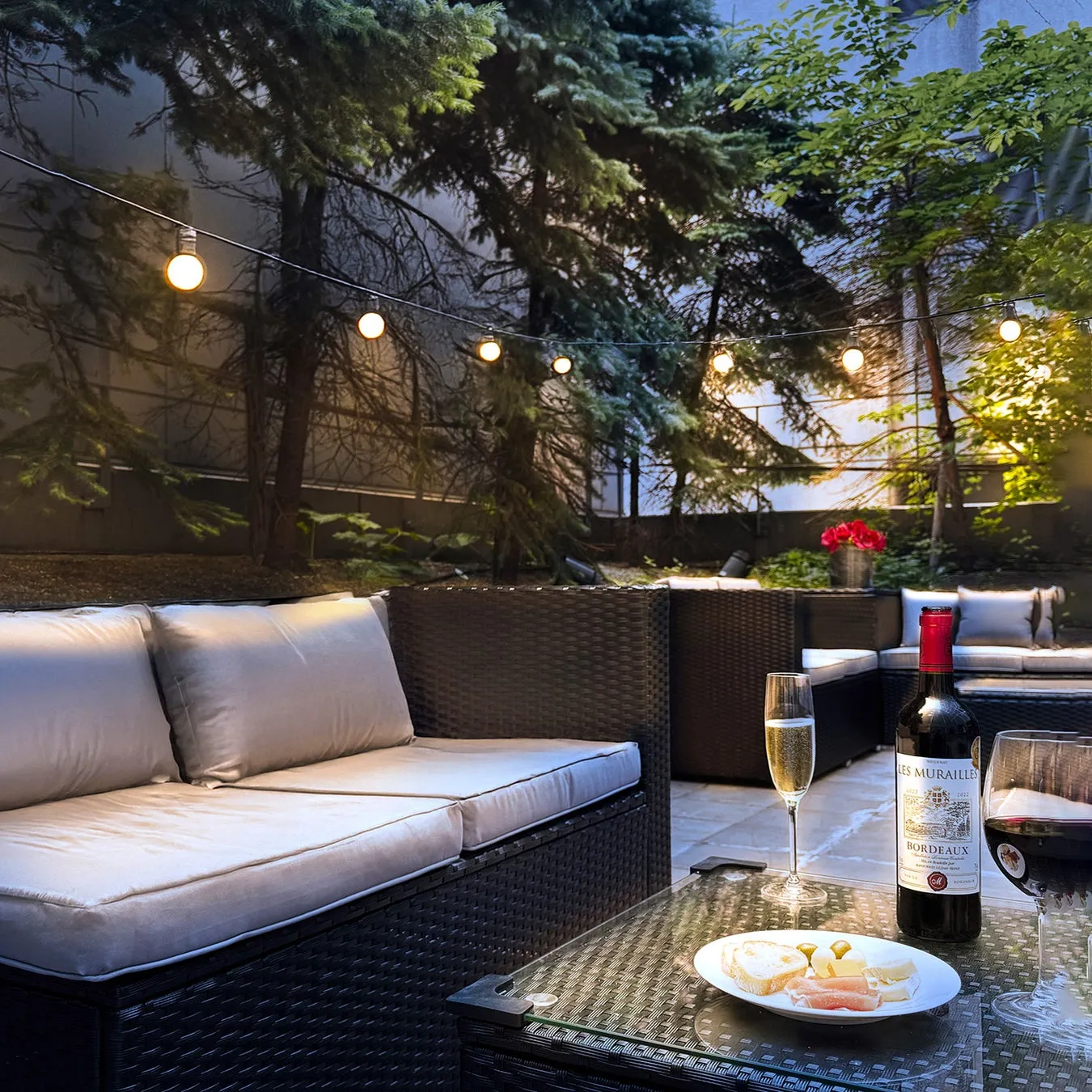 屋外のソファとテーブルにワインやチーズが置かれた、くつろいだ雰囲気。