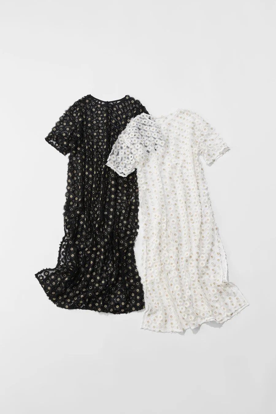 黒と白のドレスが並んだ画像。どちらも花の模様が施されており、短い袖が付いています。