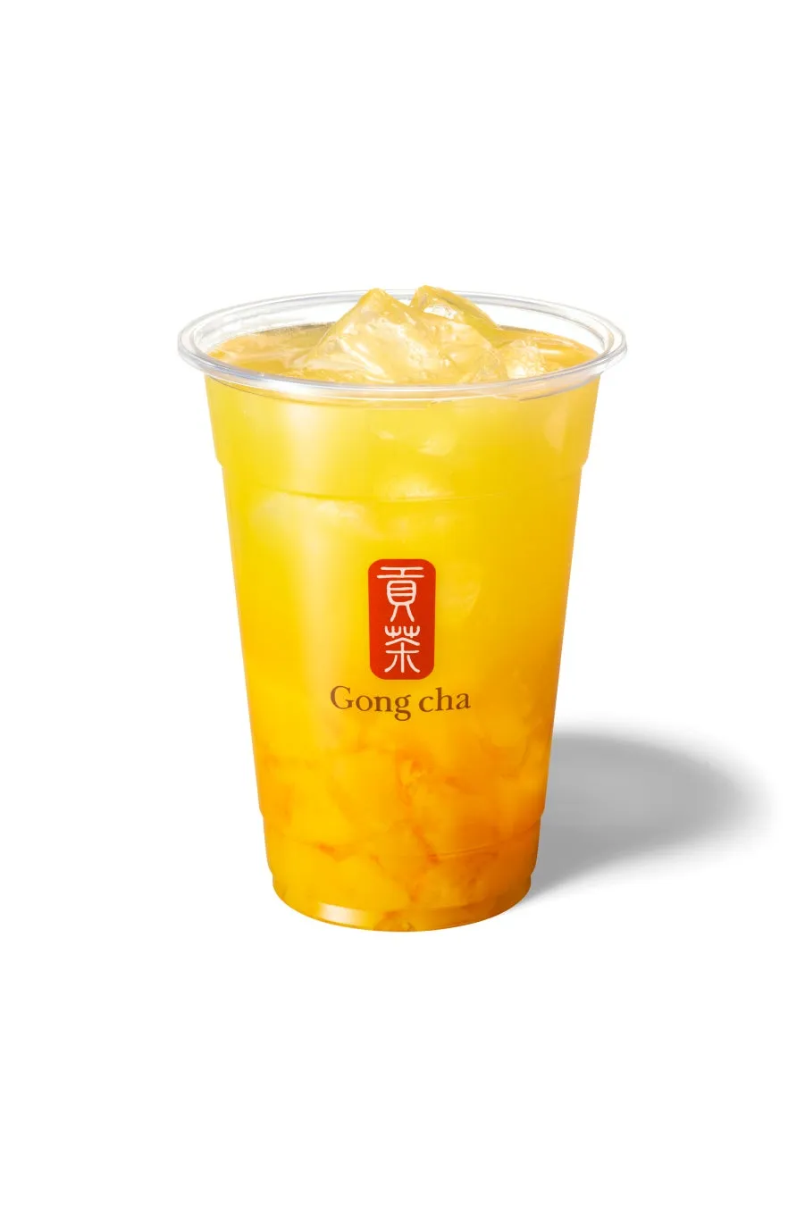 透明なプラスチックカップに入ったマンゴー味のドリンク。氷が入っており、下にはマンゴーの果肉のようなものが見える。